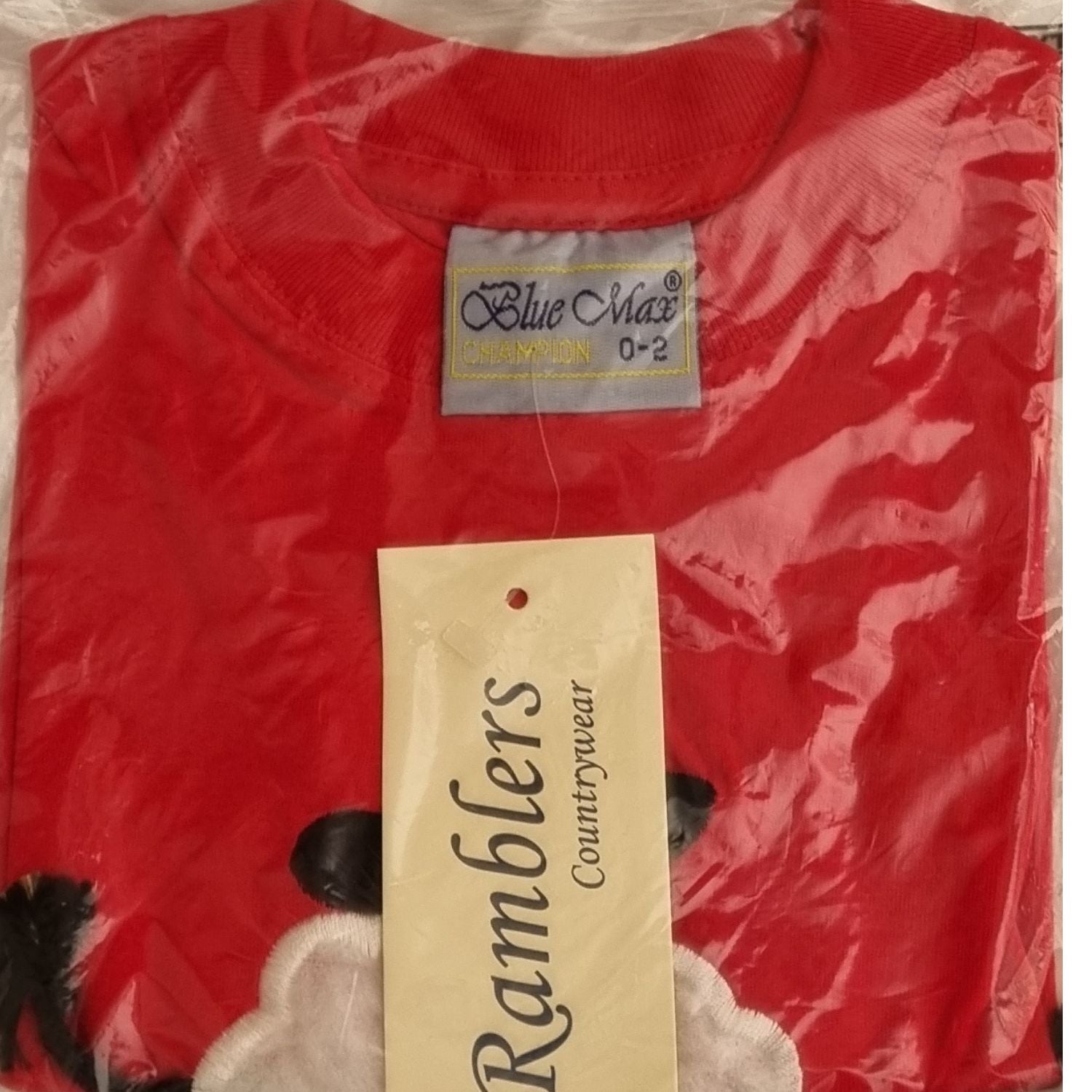 The Ramblers Sheep Embroidered T Shirt in red features an applique dangly leg lamb, made from 100% cotton, size 0-2 (Blue Max label), folded in plastic packaging with a Ramblers Countrywear tag. Machine washable for easy care.