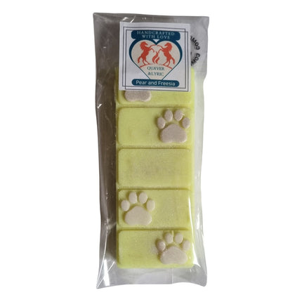a packet with quaver and lyric branding containing a yellow wax melt bar with white paw prints