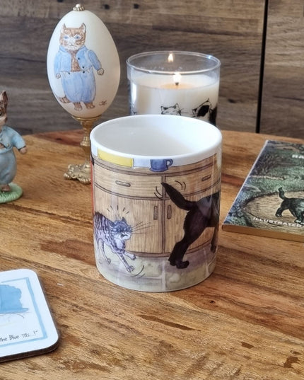 A Dog Mug by Alisons Animals featuring pre-wash cartoon design sits on a wooden table with a candle, animal figurine, themed coaster, and illustrated book—an ideal gift for animal lovers. Gift boxed.
