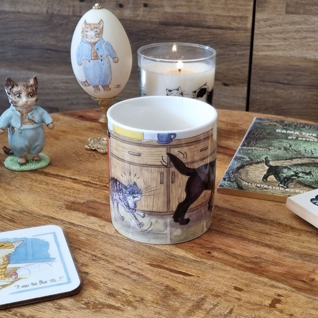 A Dog Mug by Alisons Animals featuring pre-wash cartoon design sits on a wooden table with a candle, animal figurine, themed coaster, and illustrated book—an ideal gift for animal lovers. Gift boxed.