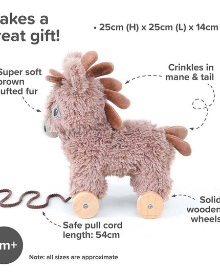 The Pull Along Toy Donkey Norbert by Little Bird Told Me UK is a plush brown donkey with wooden wheels, tufted fur, crinkled mane/tail, and a 54cm pull cord. Ideal for ages 6+ months to encourage motor skills. Size: 25x25x14cm.