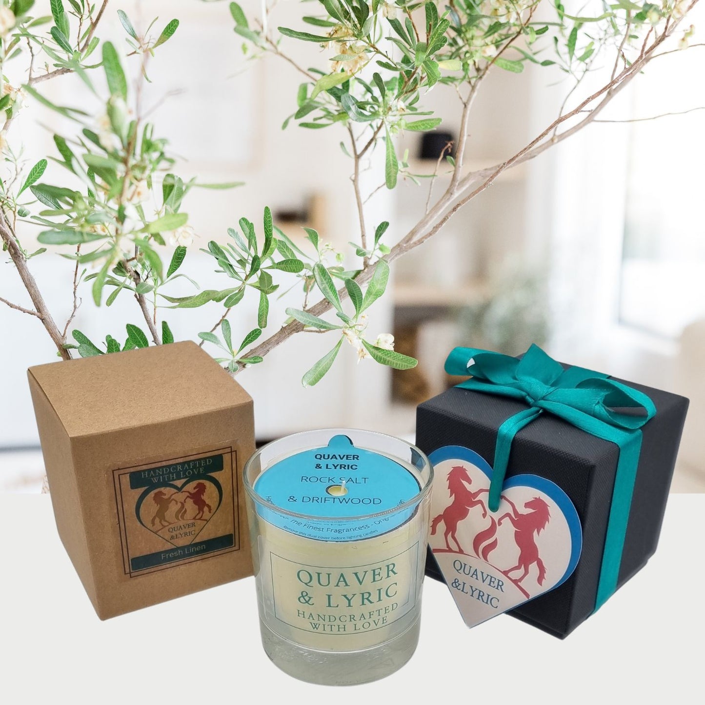 a scented candle with quaver and lyric handcrafted with love label next two a kraft box and black luxury gift box