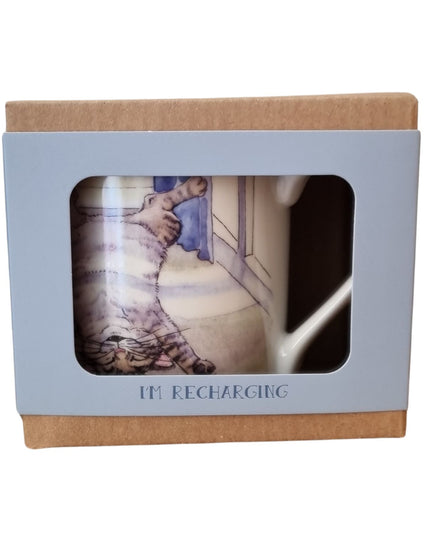 The Alisons Animals Cat Mug features a playful Re-charging cartoon of a cat on its back, packaged in a light brown and blue gift box with “IM RECHARGING” below the window—perfect for cat lovers.