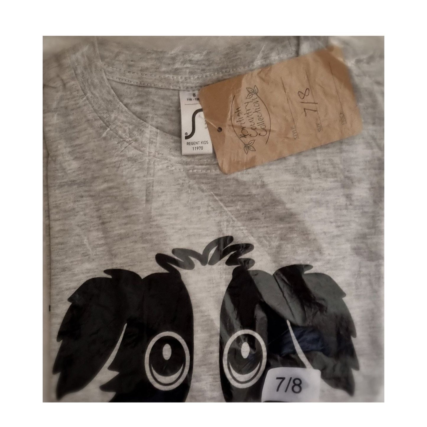 The British Country Collection Childrens T Shirt features a soft cotton fabric, Rex the Dog print with big eyes and dark ears, clear packaging, a brown tag, and a size 7/8 label.