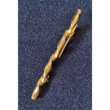 The Equinaliagifts Stock Pin Ribbon Design For Equestrians Horse Riders, featuring a gold-toned twisted look perfect for competition wear, is showcased on a dark blue textured fabric background.