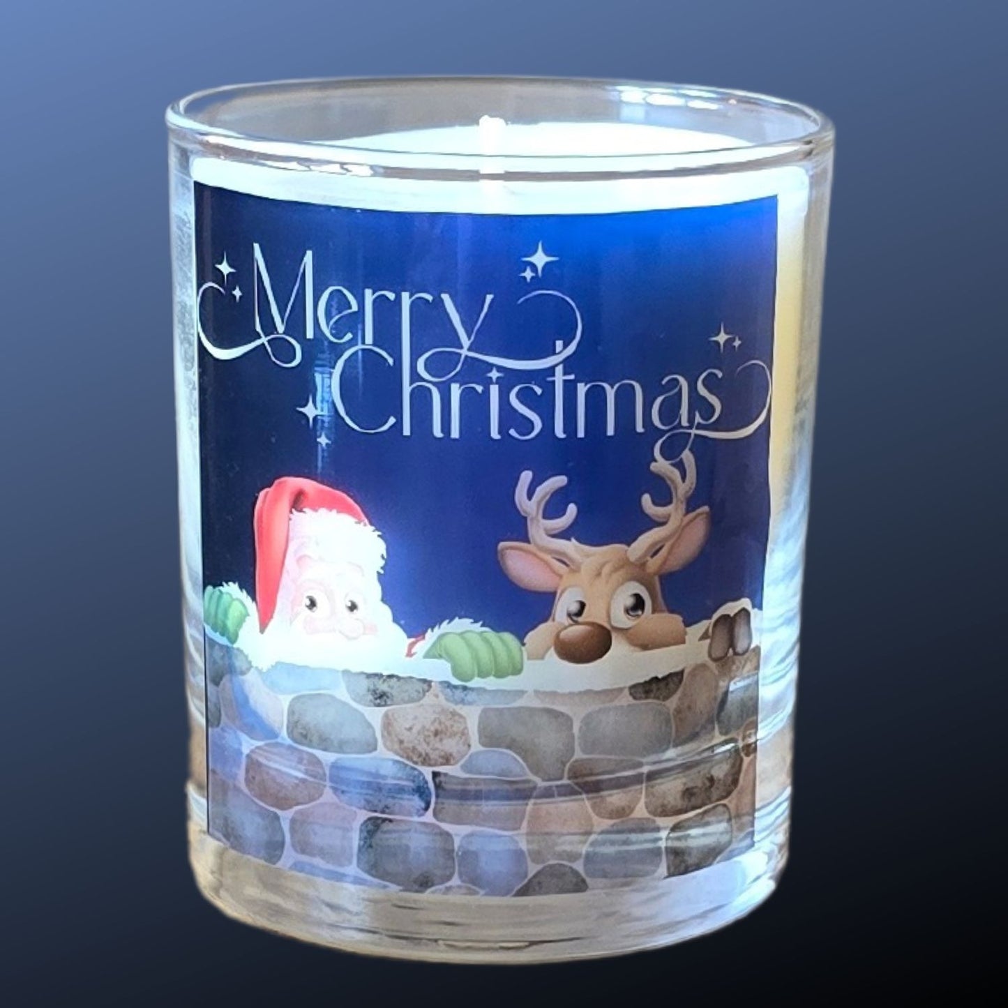 A Christmas scented candles with a charming Merry Christmas design featuring Father Christmas and a reindeer peeping over a wall.