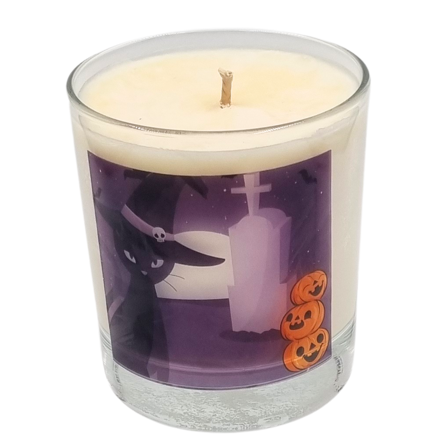 glass container halloween candle with black cat in witches hat in a graveyard with pumpkins