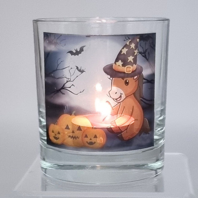 a lit halloween tealight holder with a cute cartoon pony and pumpkin design