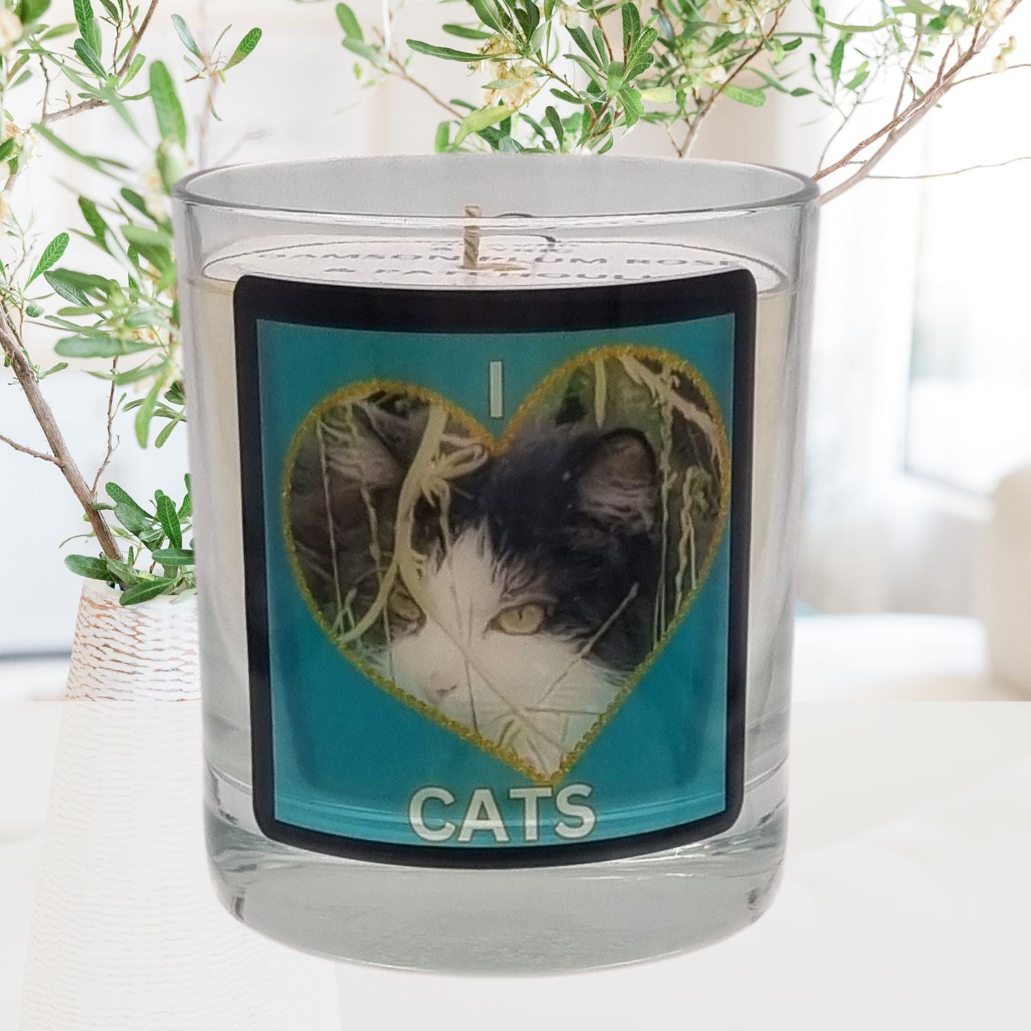 scented candle in glass container with fluffy black and white cat in a heart love cats design in a room setting 