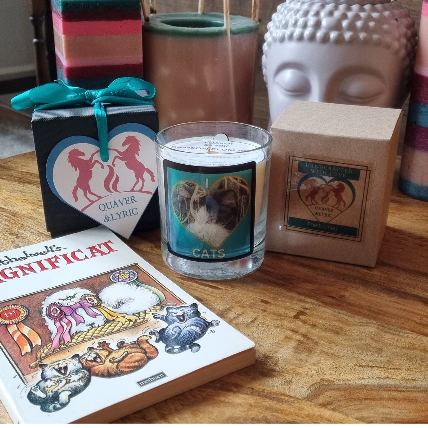 scented candle in glass container with fluffy black and white cat in a heart love cats design on a table with the packaging and gift box