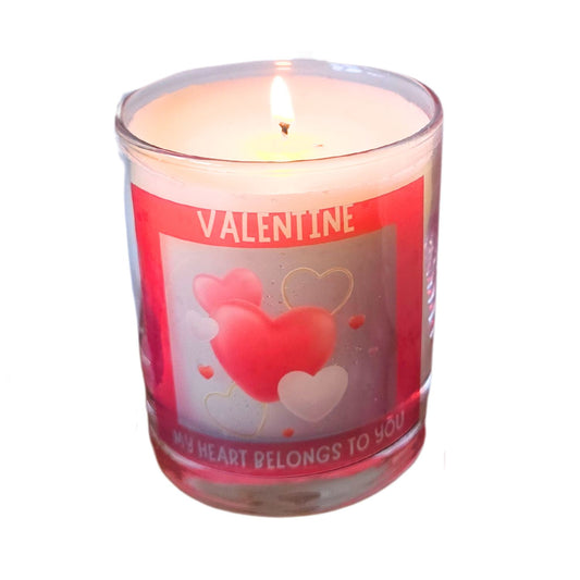 a lit valentine candle in a glass container with red heart design