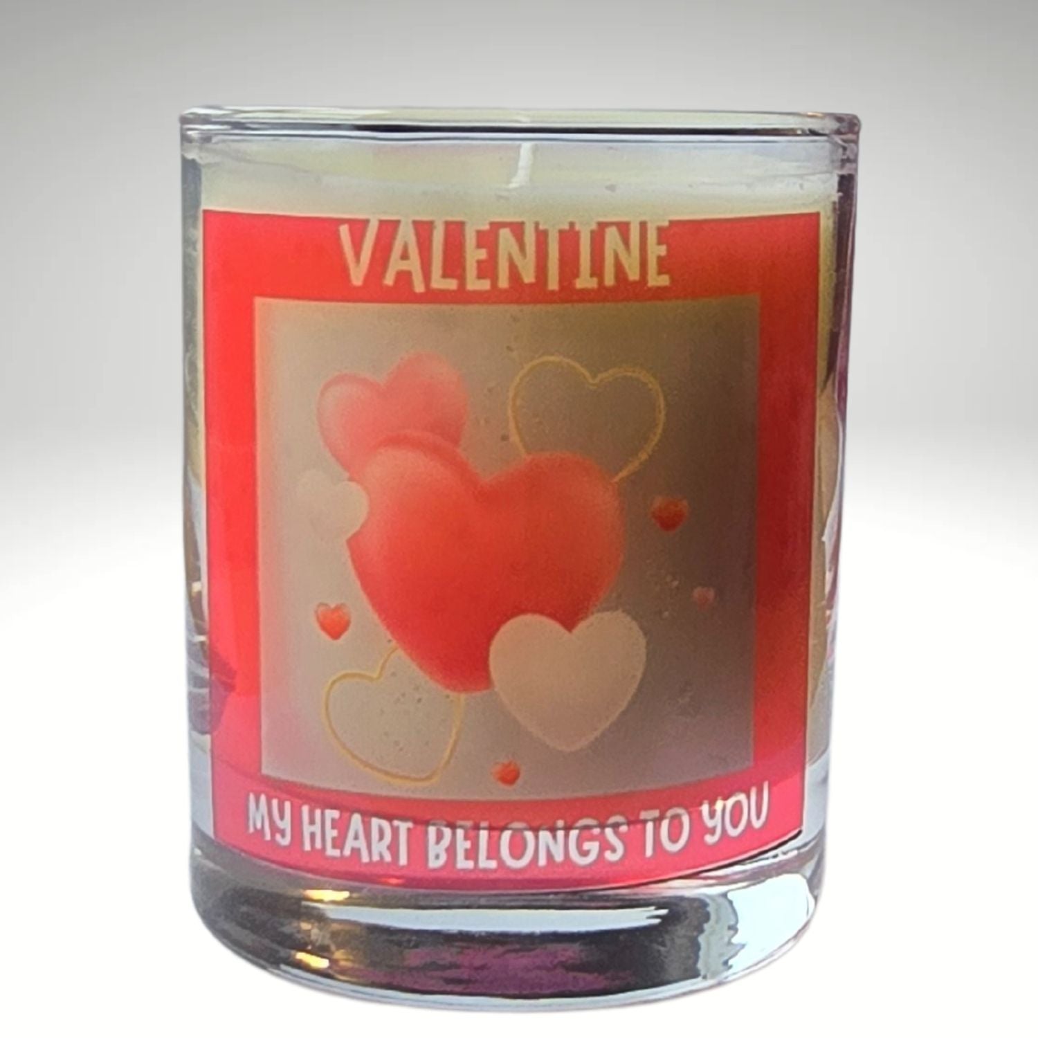 a valentine candle in a glass container with red heart design