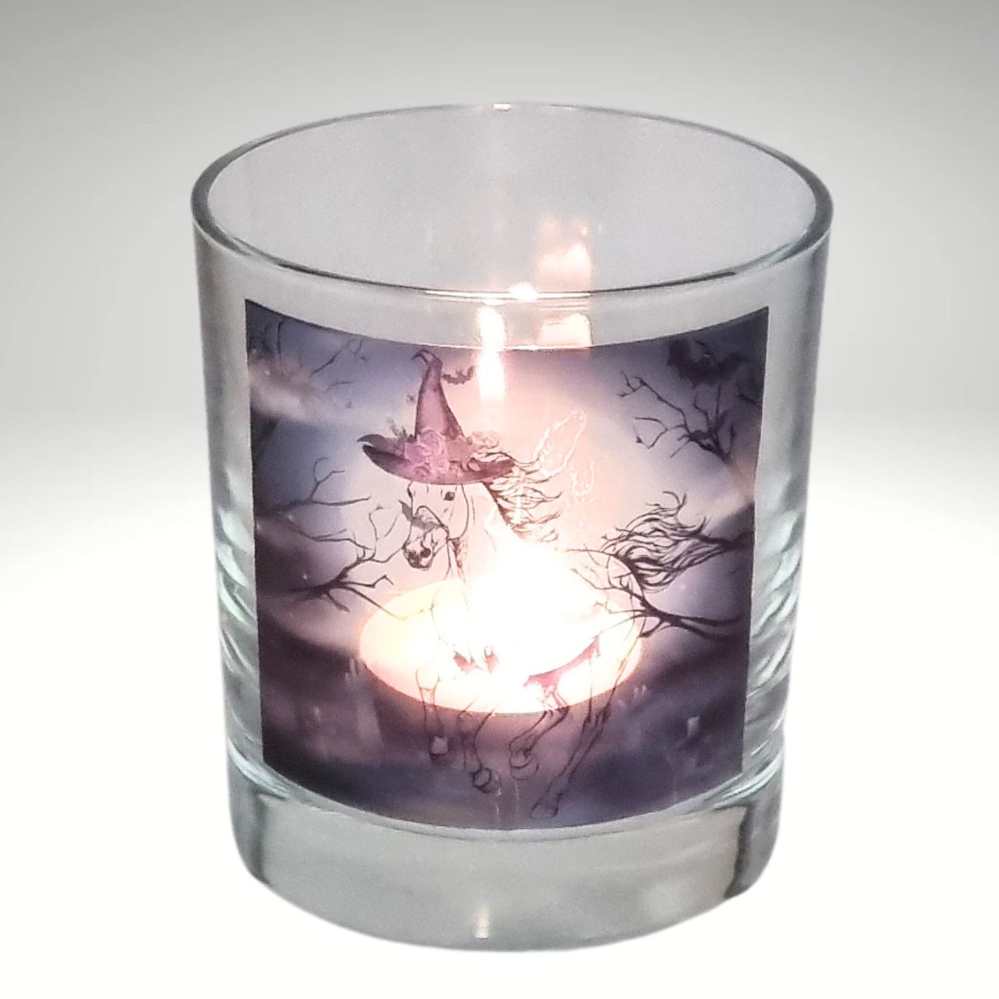 a lit halloween tealight candle holder featuring a spooky galloping horse design