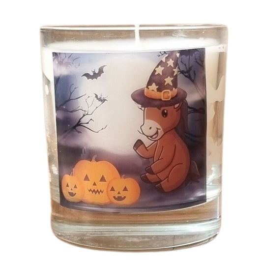 a scented Halloween candle in a glass container with a cute cartoon pony and pumpkin design