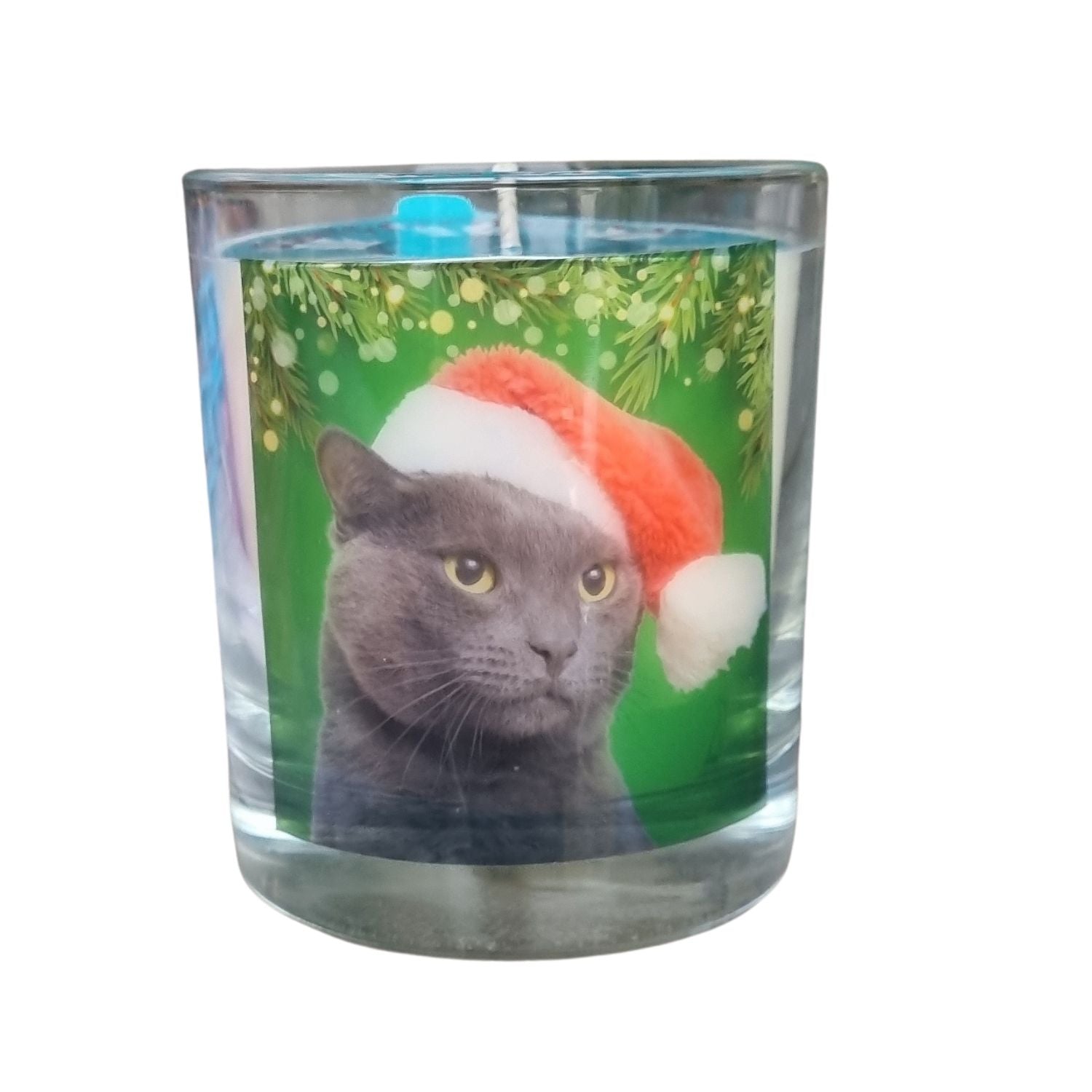 A scented candle in a glass container with a cute grey cat in a Santa hat.