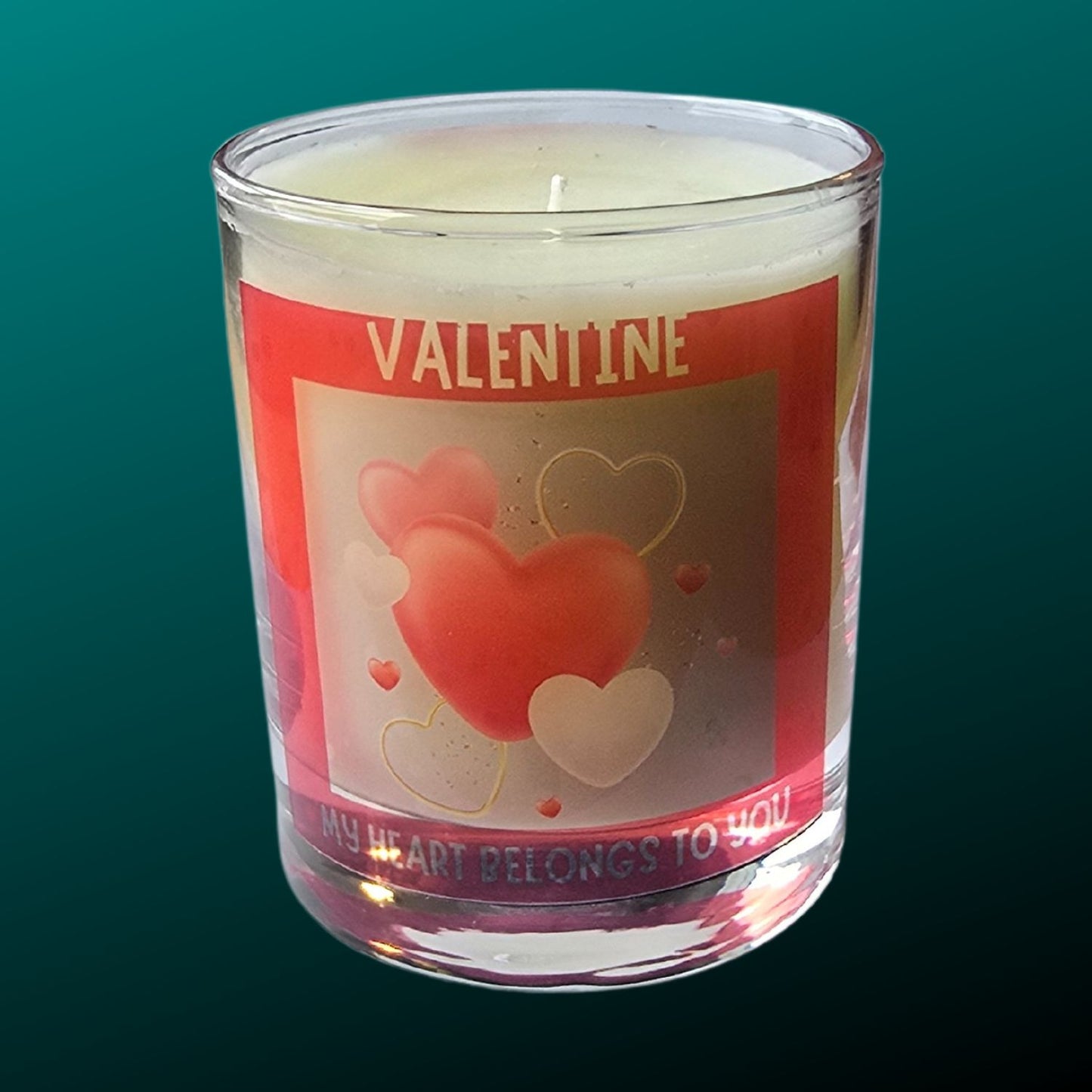 a valentine candle in a glass container with red heart design