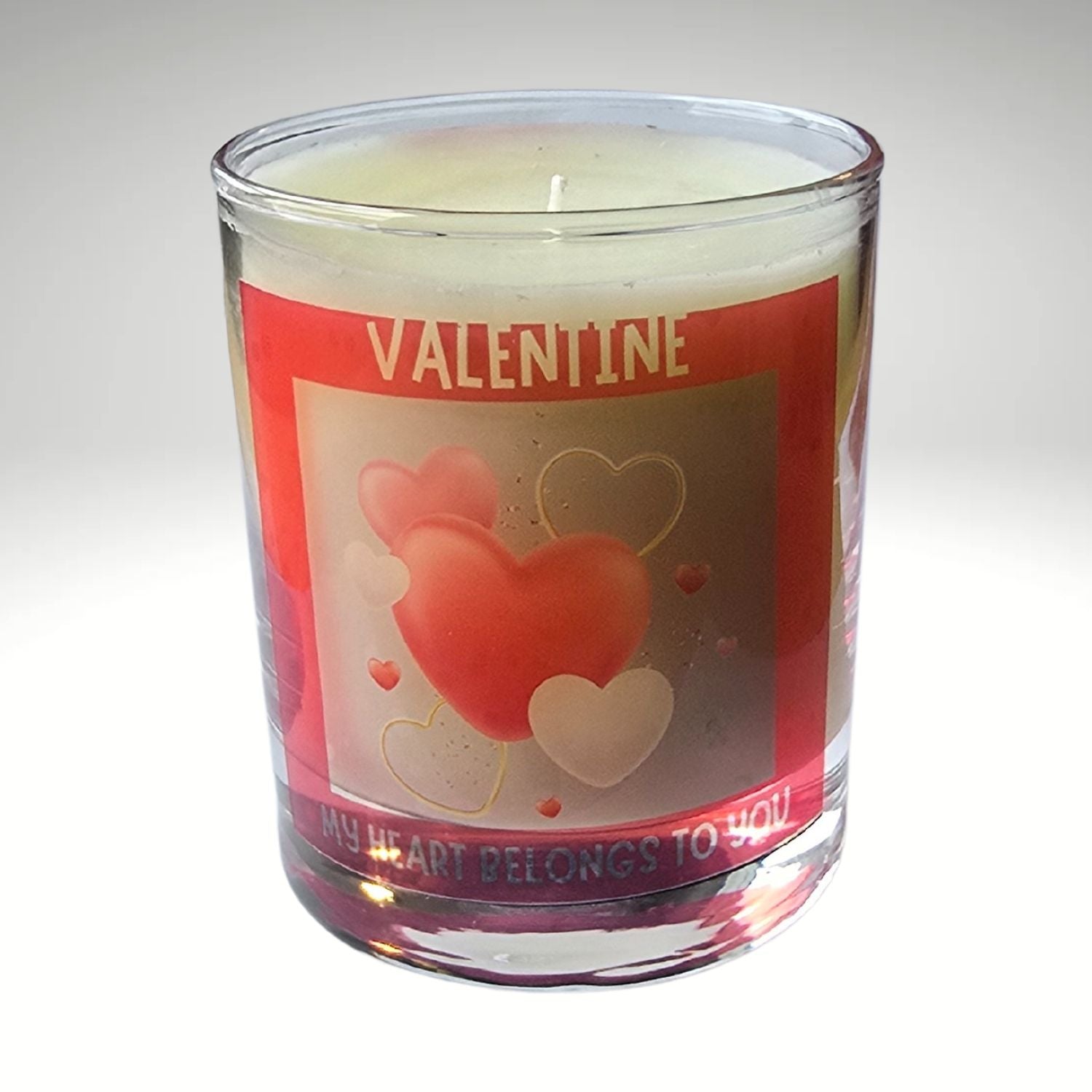 a valentine candle in a glass container with red heart design