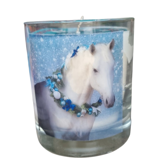 a scented candle in a glass container with a grey horse wearing a festive garland on his neck