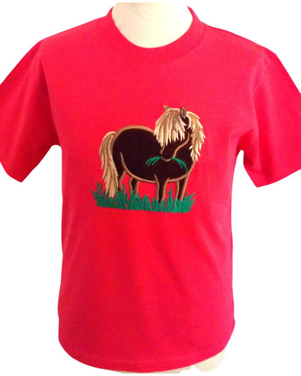 A fuschia pink short sleeve, round necked T-shirt featuring an embroidered design of a brown shetland pony with a cream mane and tail eating a mouthful of grass