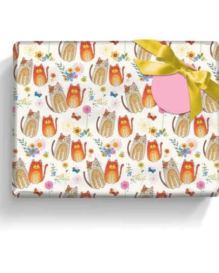 a present wrapped in pretty gift wrap paper with cute brown and orange cats and flower on a white background with a pink  gift label