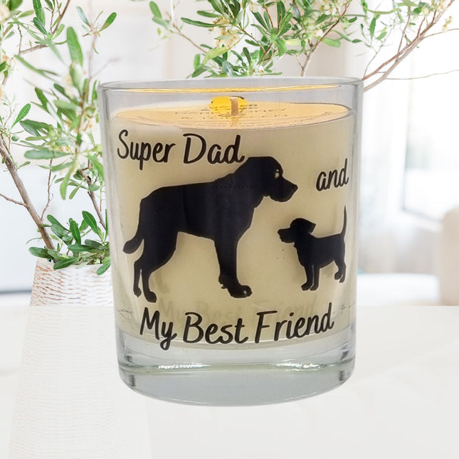 The Quaver&Lyric Dog Fathers Day Gift Scented Candle (30cl) features “Super Dad” and “Best Friend” with dog silhouettes—an ideal gift for dog-loving dads. Blurred green leafy branches appear in the background.