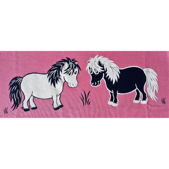 Illustration of two cartoon Shetland ponies, one white and one black, with shaggy manes on a pink background with grass, featured on the Pony T Shirt Printed Pink Childrens Two Shetlands by British Country Collection.