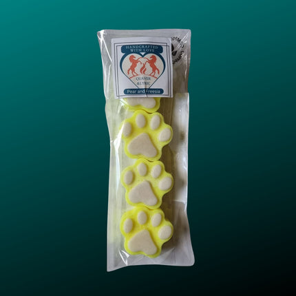 four bright yellow paw shaped wax melts with white paw pads in a packet with quaver & lyric rearing horse branding