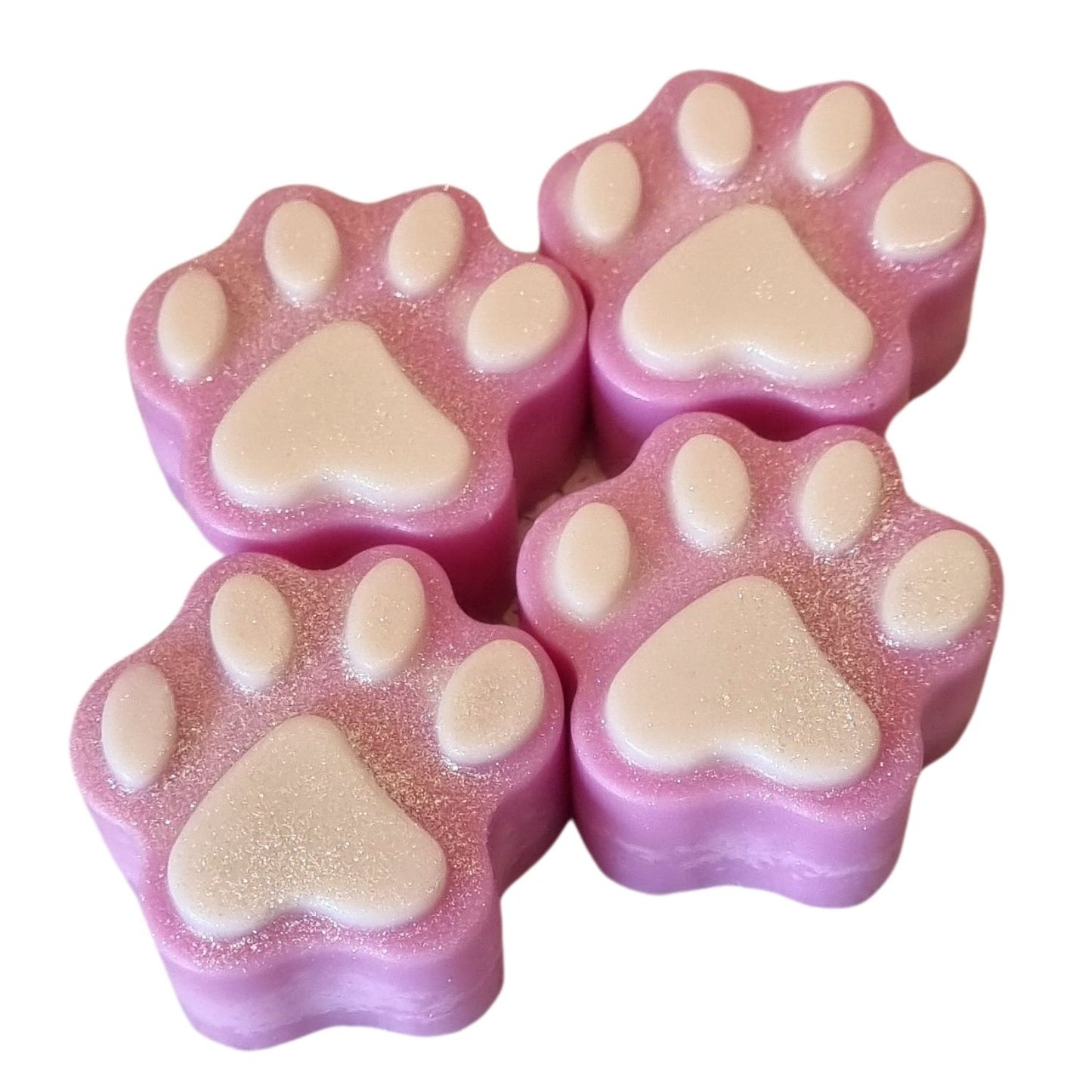 a group of four pink paw shaped wax melts with white paw pads