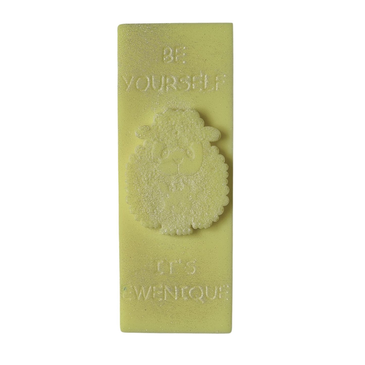 A bright yellow coloured wax melt bar with a raised sheep design with the writing be yourself above and it's ewenique below.
