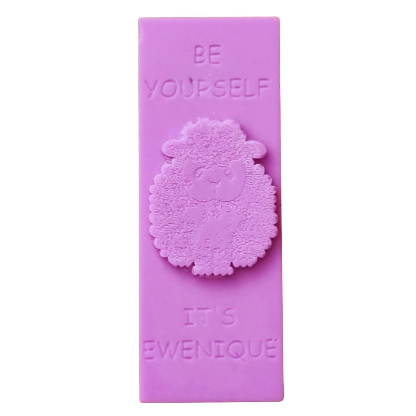 A vivid pink coloured rectangle of wax with a raised sheep design with the writing be yourself above and it's ewenique below.