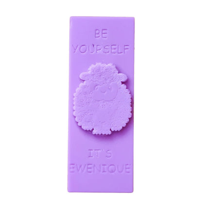 A purple coloured wax melt bar with a raised sheep design with the writing be yourself above and it's ewenique below.