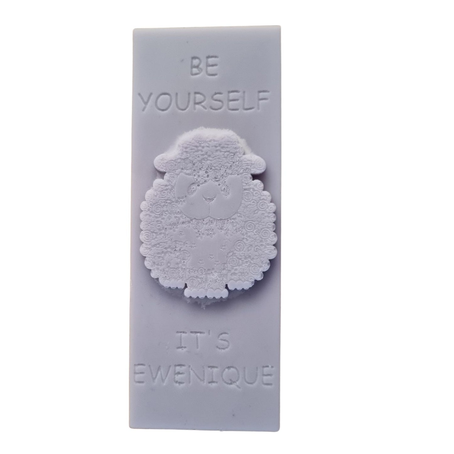 A lilac coloured wax melt bar with a raised sheep design with the writing be yourself above and it's ewenique below.