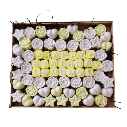 a kraft box containing yellow and white wax melts spelling out the message Happy Birthday Mum