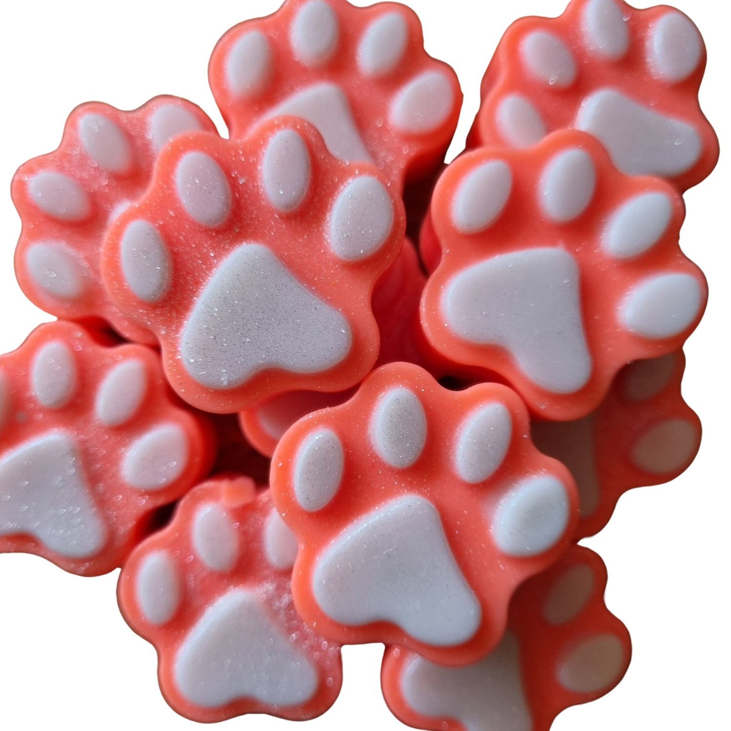 a group of orange paw shaped wax melts with white paw pads