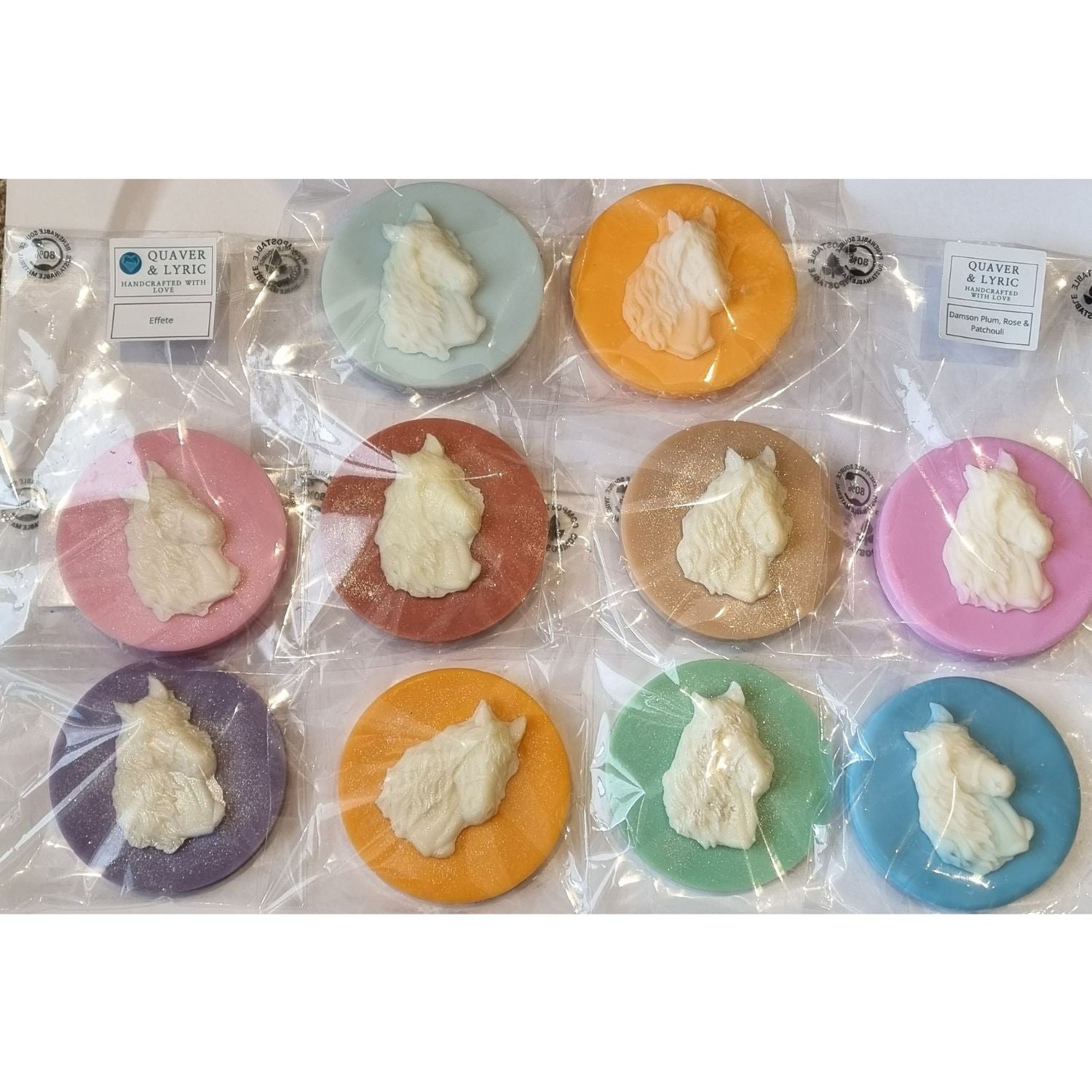 a group of coloured disc shaped wax melt with a white wax horses head with a flowing mane and forelock.