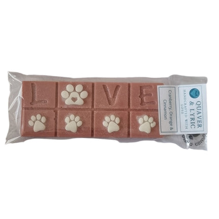 A packet with quaver and lyric branding containing a Scented Wax Melt bar with love and white paw prints 