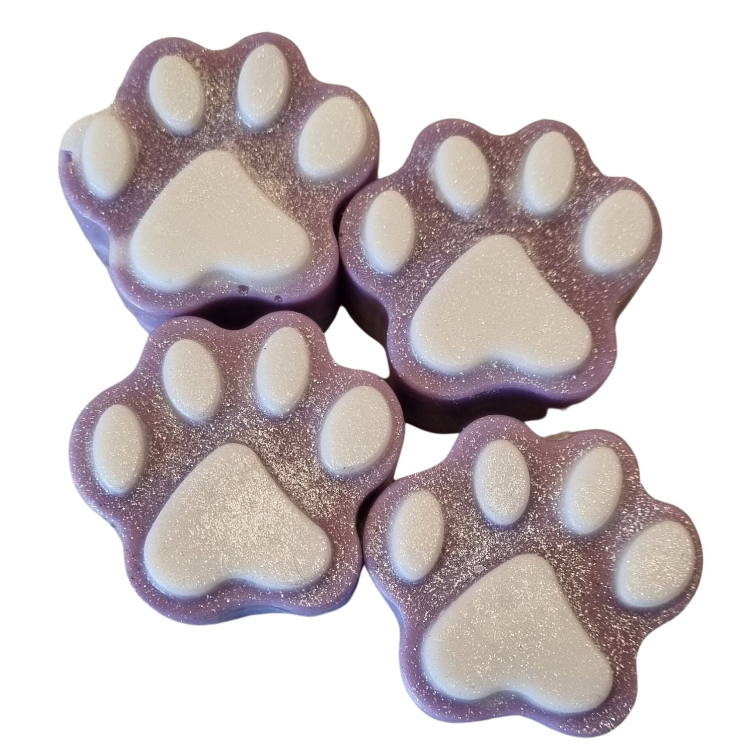 a group of four violet paw shaped wax melts with white paw pads