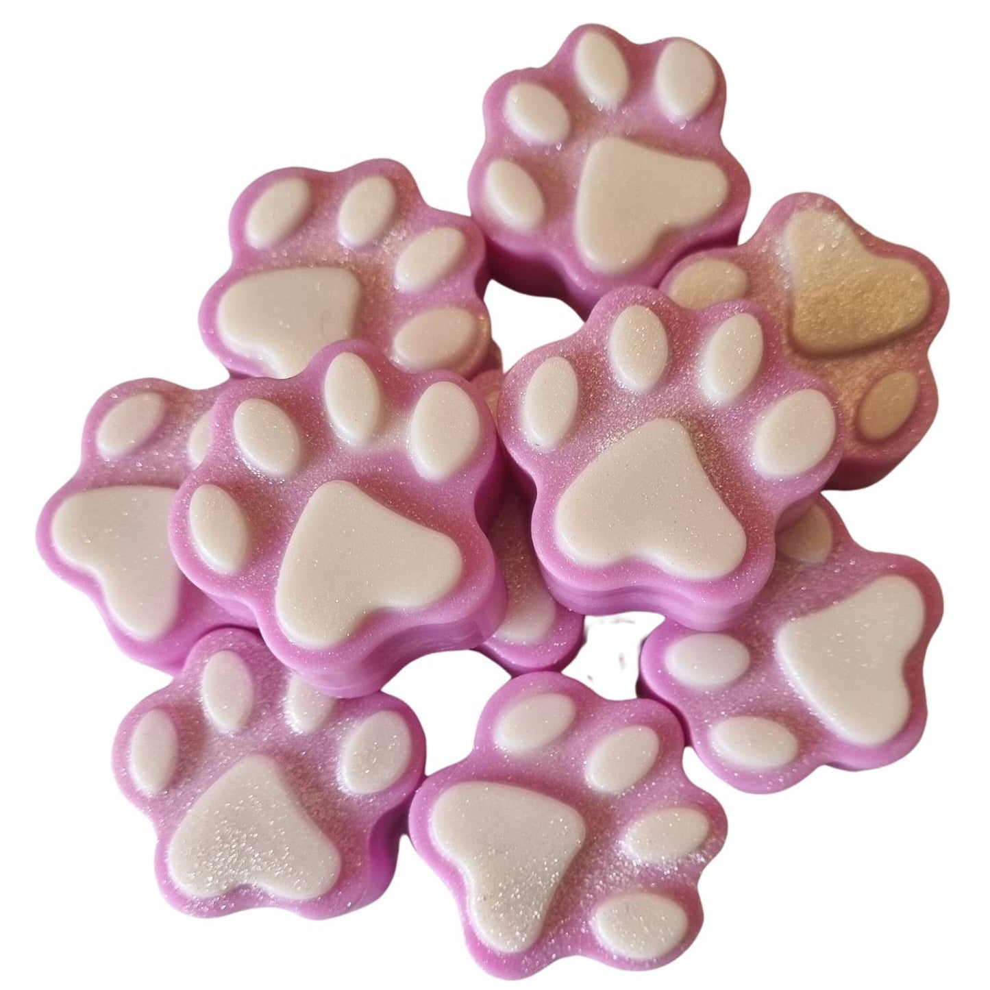 a group of pink paw shaped wax melts with white paw pads