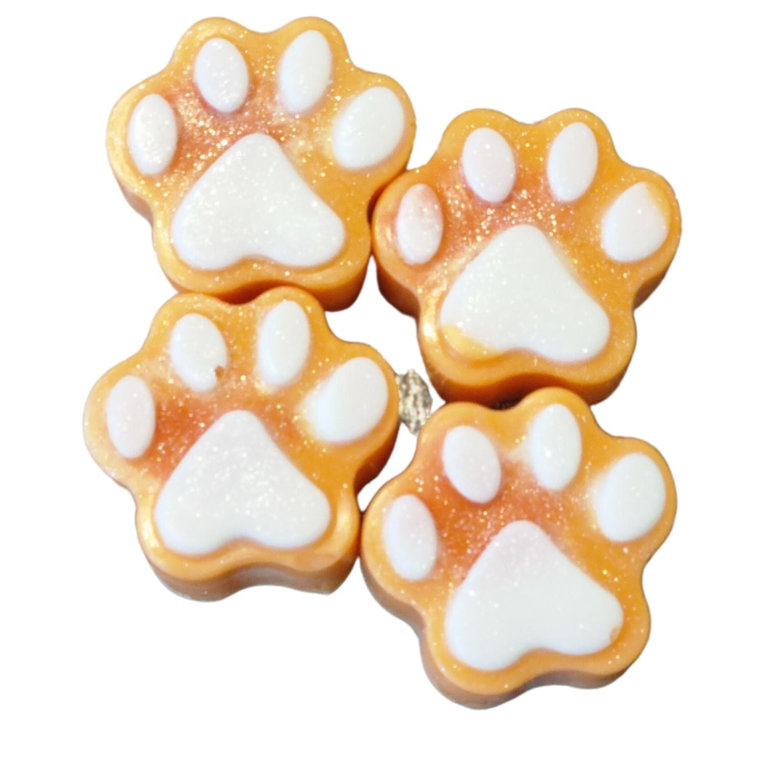 a group of four orange paw shaped wax melts with white paw pads