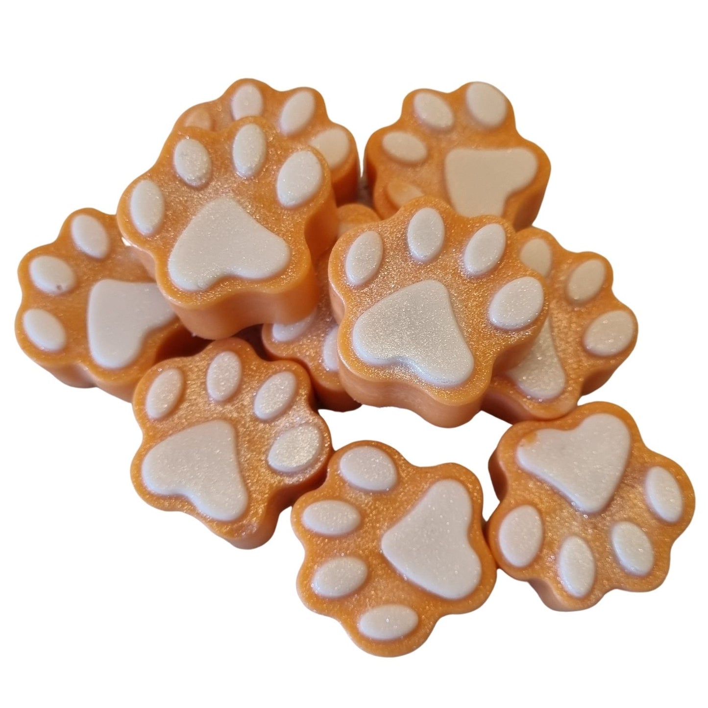 a group of pale orange paw shaped wax melts with white paw pads