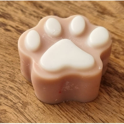 a brown Paw Shaped Soy Wax Melt  with white pads on a wooden table