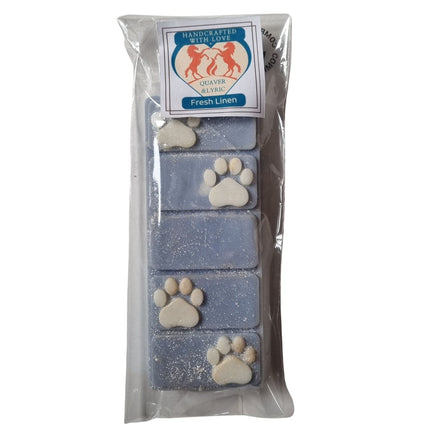 a packet with quaver and lyric rearing horse branding containing a blue fresh linen fragranced wax melt bar with white paw prints