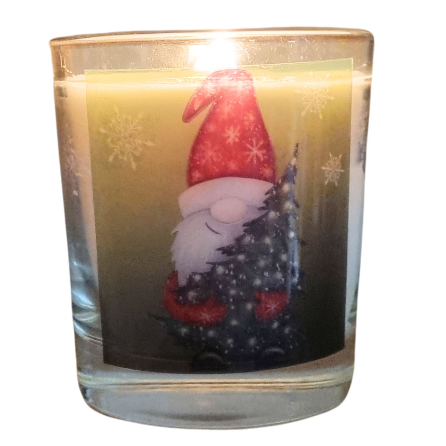 A burning Father Christmas candle with father christmas holding a christmas tree design on the front of a scented candle in glass container.